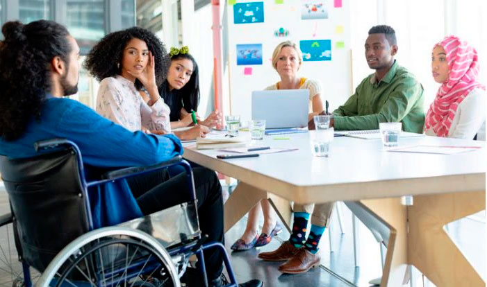 Estudiantes y profesionales participando en una reunión inclusiva con representación de personas con discapacidad y diversidad cultural